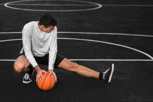 basketball-player-stretching-court_23-2148393830
